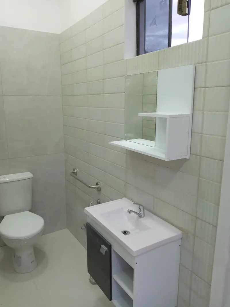 Bano terminado con bacha y espejo, consultorio San Lorenzo - OGA Constructora