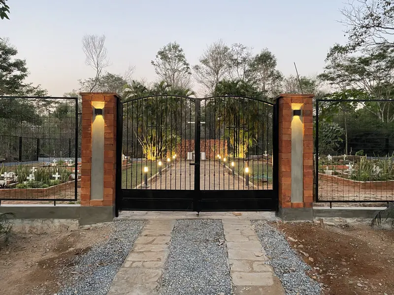 Porton de acceso con columnas iluminado al atardecer, memorial Hermanas Dominicas - OGA Constructora
