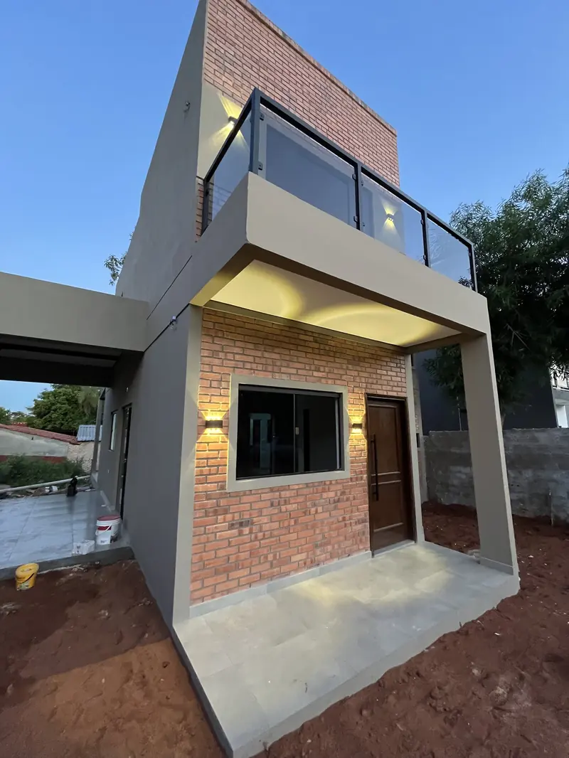 Esquina de vivienda de dos plantas en ladrillo visto y revoque blanco, San Lorenzo - OGA Constructora