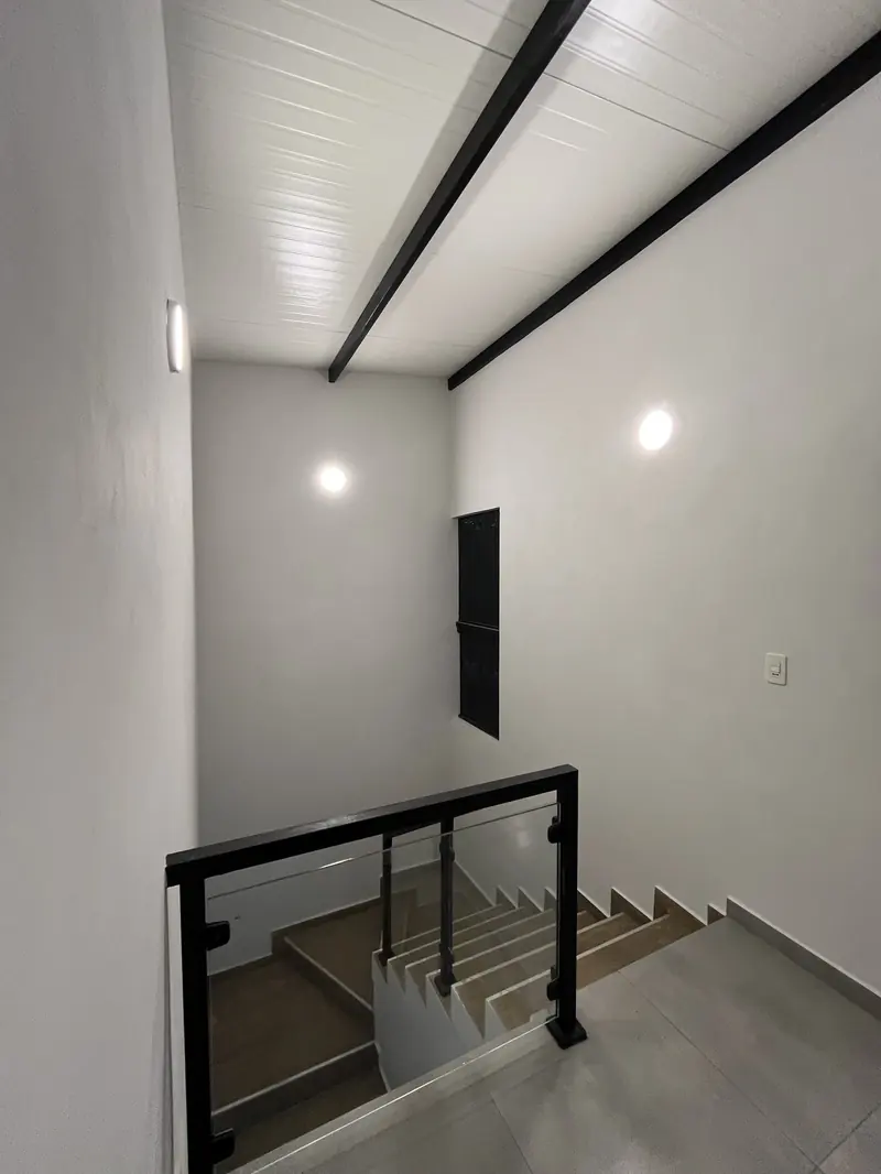 Escalera con baranda metalica negra y entrepiso, vivienda Mile San Lorenzo - OGA Constructora