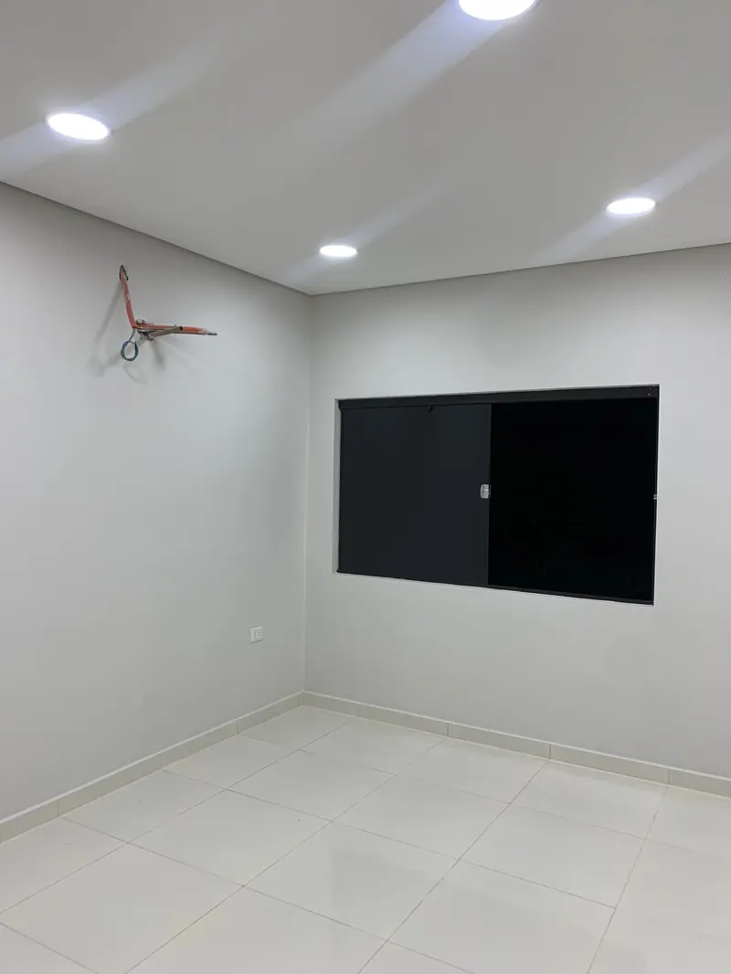 Ambiente interior blanco con television y ventilador de techo, vivienda Ruben Aranda Luque - OGA Constructora